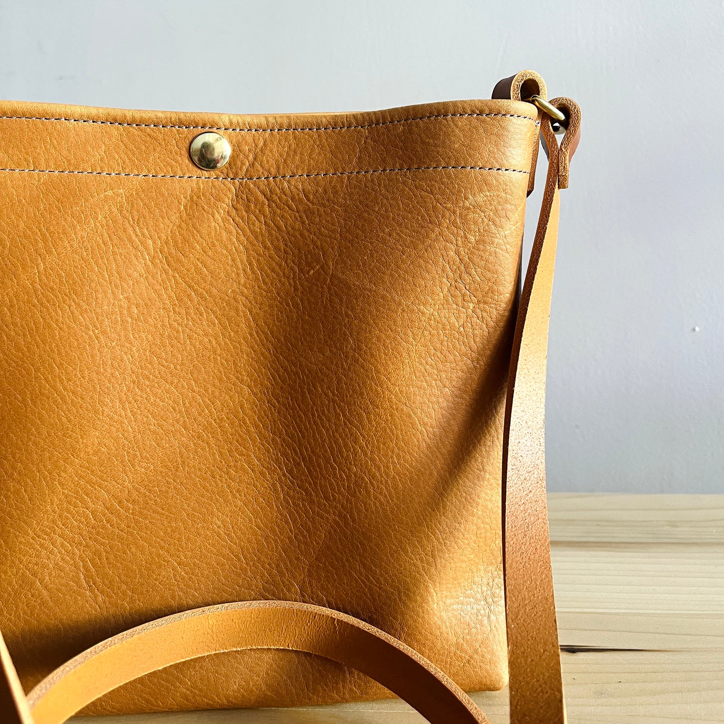 Tan leather crossbody bag with snap
