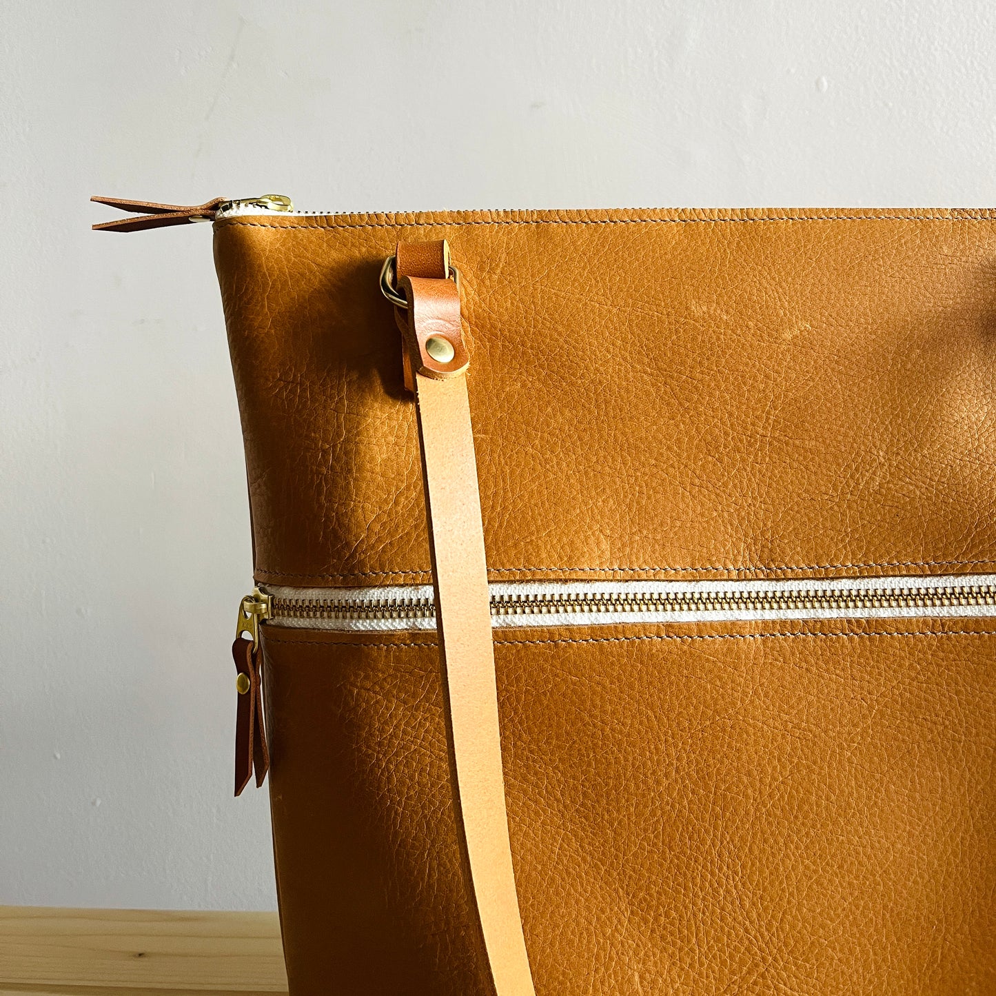 Close up of tan leather bag by Suzanne Faris