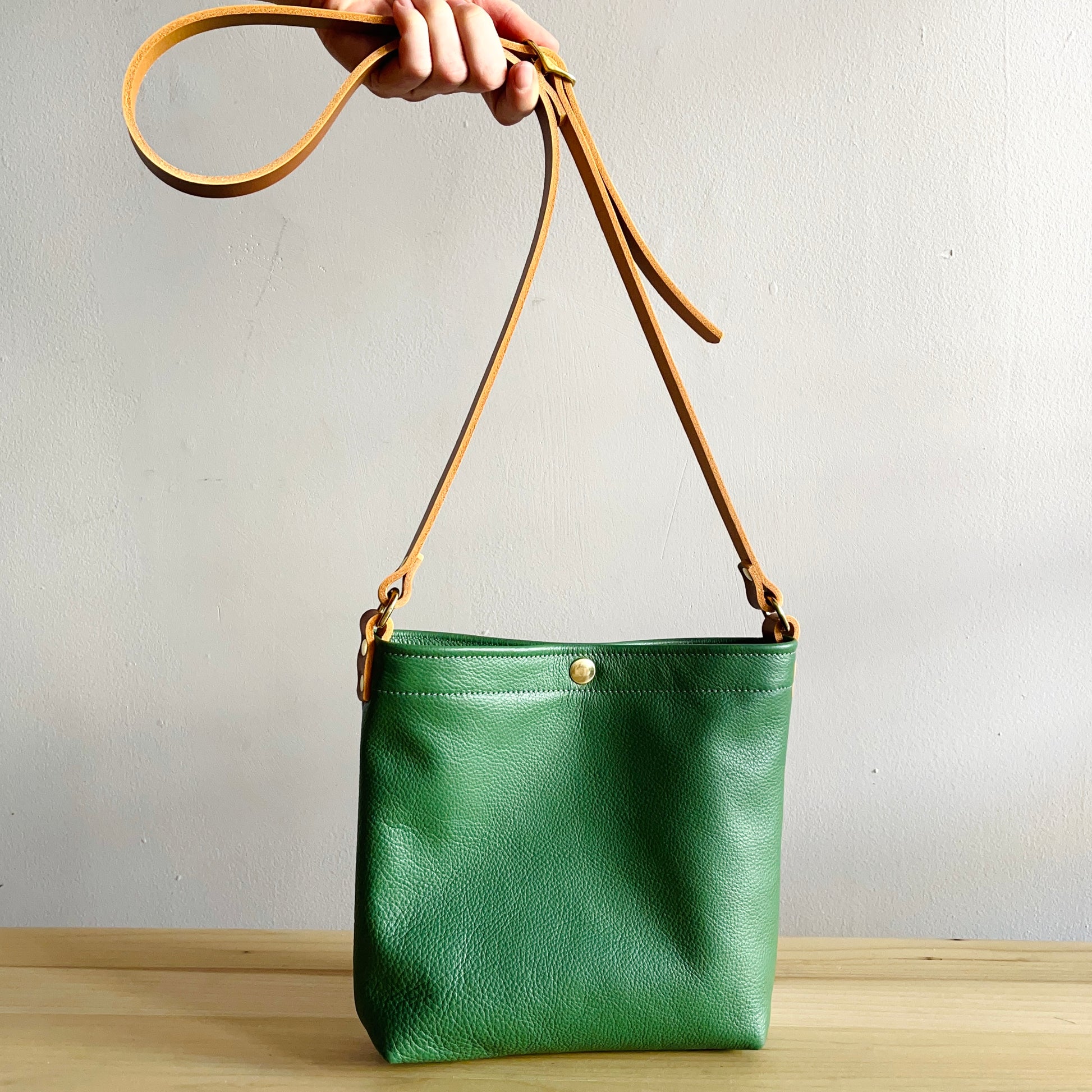 moss green leather crossbody bag with brown handle