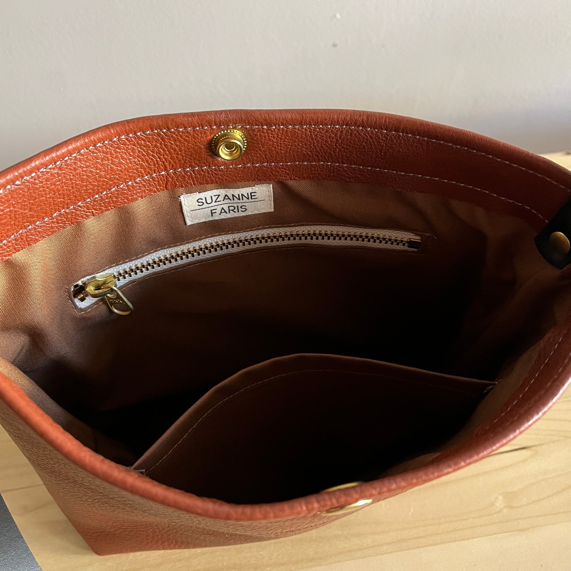 brown interior of cognac leather handbag with snap and crossbody